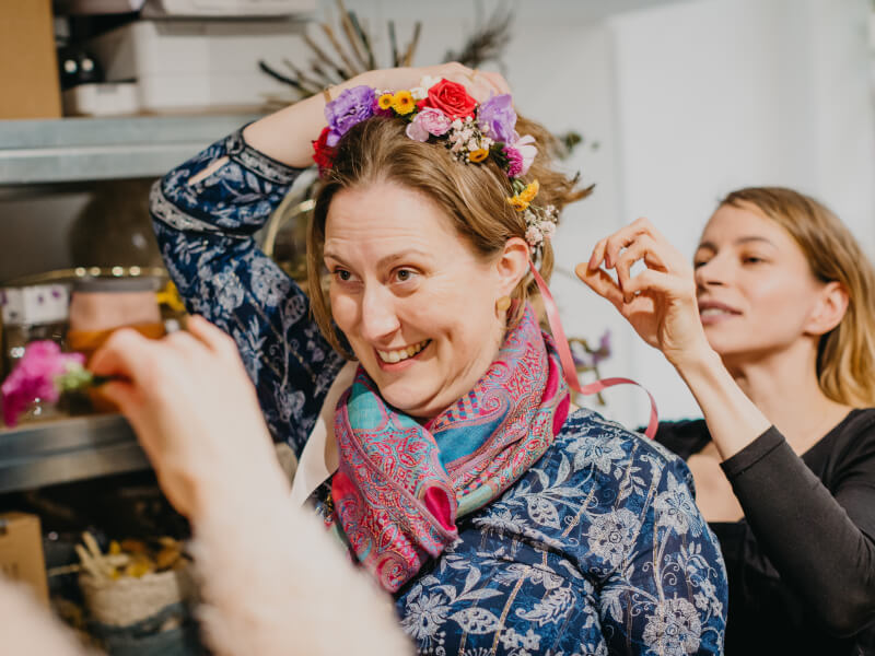 A lady puts on a handmade flower crown.